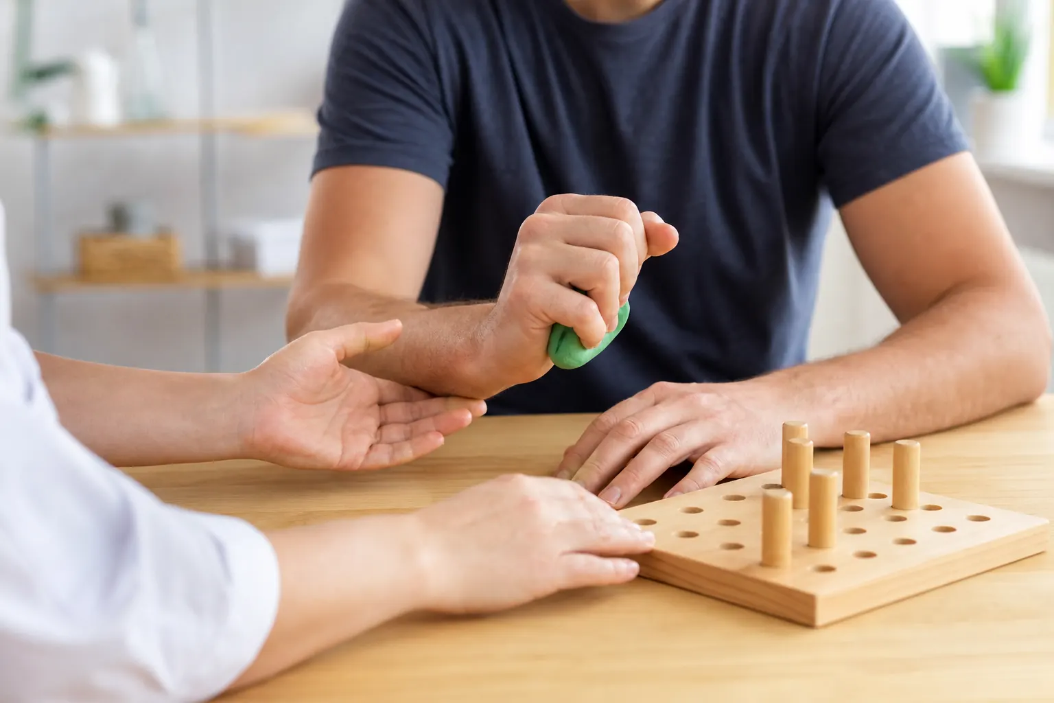 Handtherapie und Bewegungsübungen an einem hellen Therapietisch